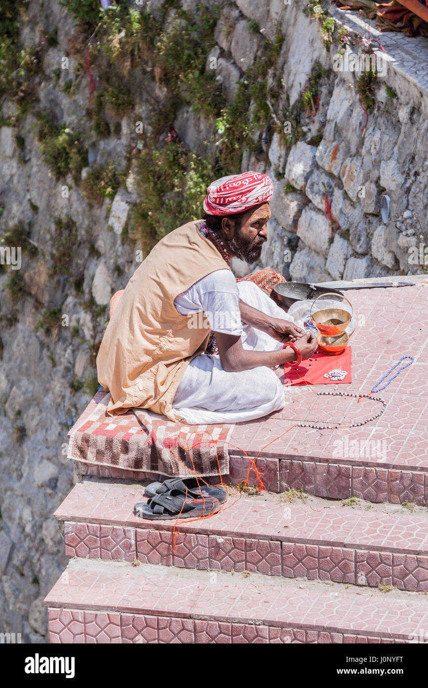 BADRINATH - INDIA, 5 giugno - Un sadhu vende perline di santo sui gradini nei pressi del tempio di Badarinath in India del Nord il 5 giugno 2013 Foto Stock