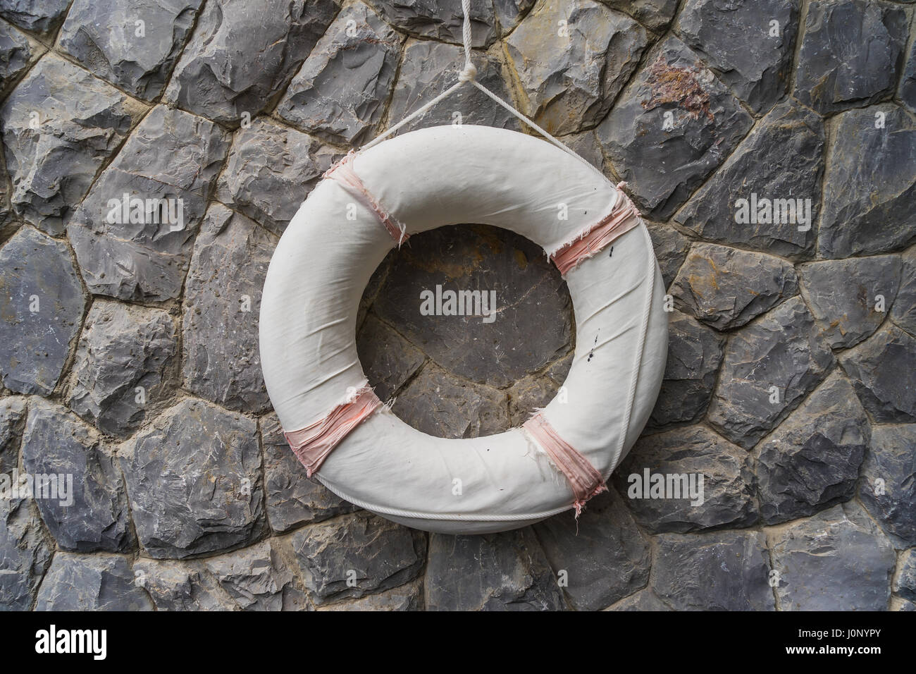 Per salvare la vita di gomma, ciambella, appeso alla parete di roccia, muro di pietra Foto Stock