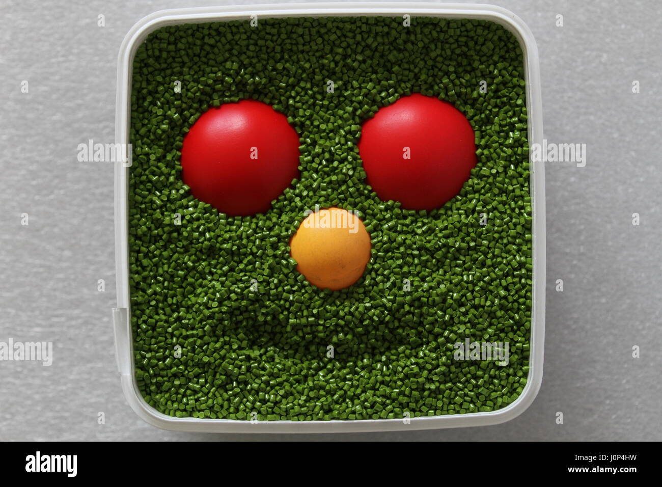 Il design creativo. Dell'opera dell'autore. Sorriso. Faccia di plastica. Emoticon per uso in giochi per computer e web design. Emoticon verde con rosso e giallo occhi naso. Foto Stock