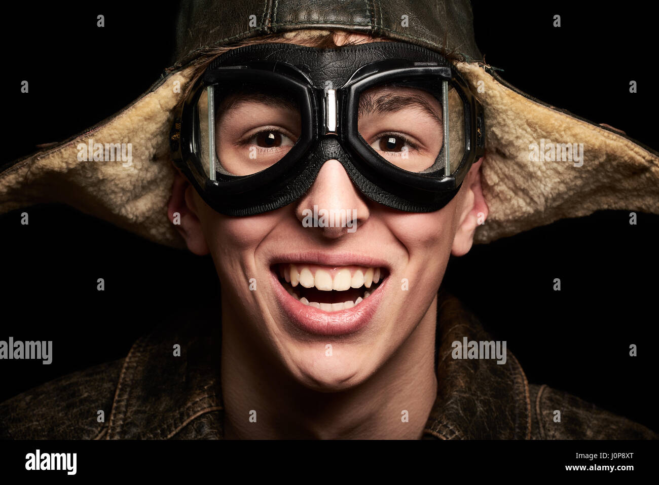 Giovane uomo con cappello e occhiali look vintage su sfondo nero Foto Stock