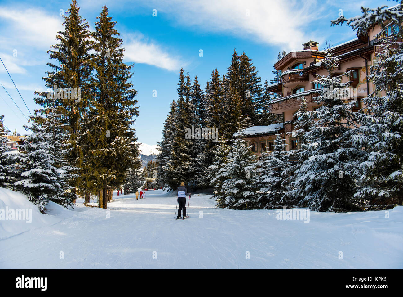 Sciatore su una neve piste da sci piste da sci in inverno alpine resort di montagna con boschi di conifere di alberi di pino e hotel Foto Stock