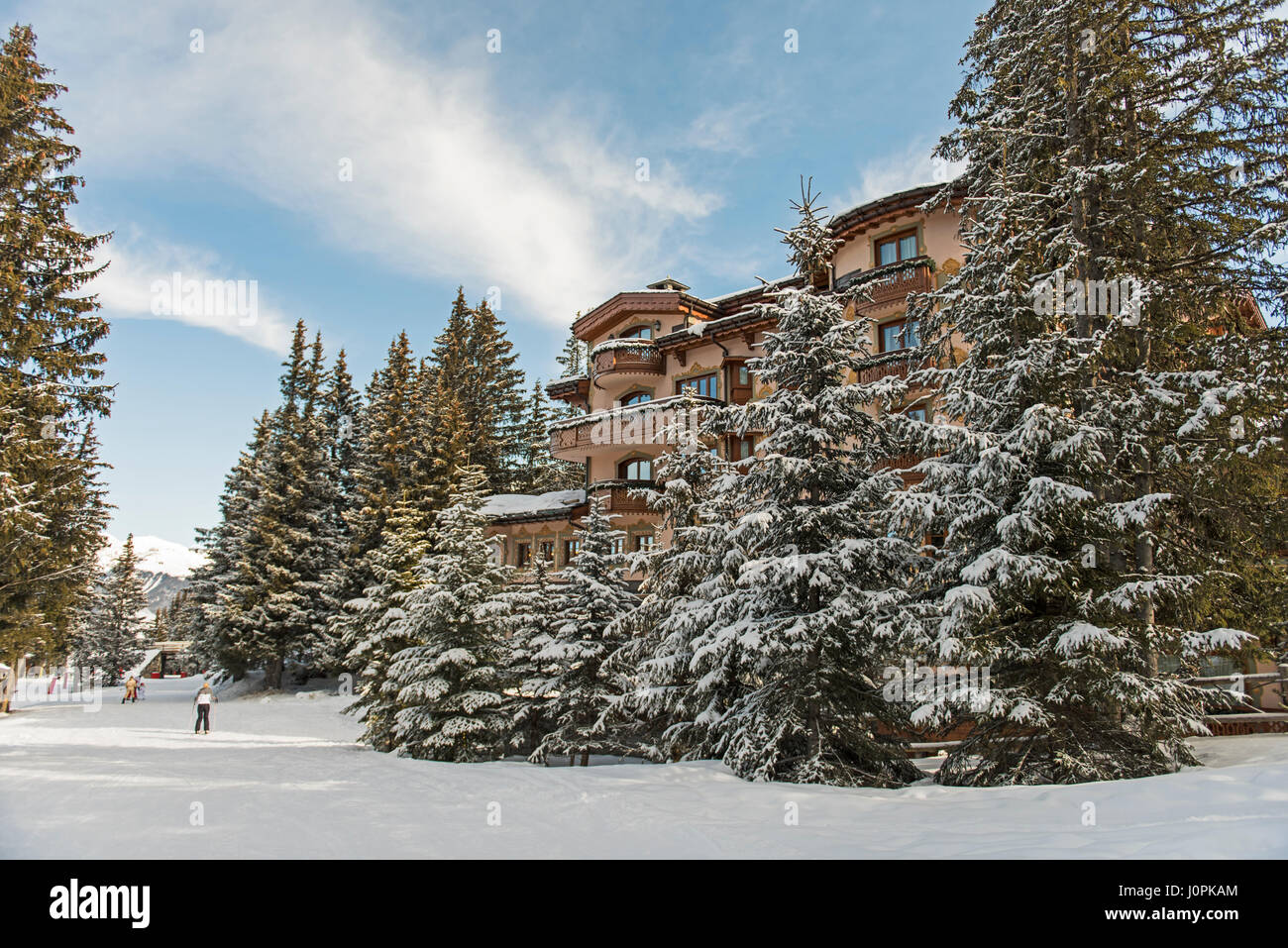 Sciatore su una neve piste da sci piste da sci in inverno alpine resort di montagna con boschi di conifere di alberi di pino e hotel Foto Stock