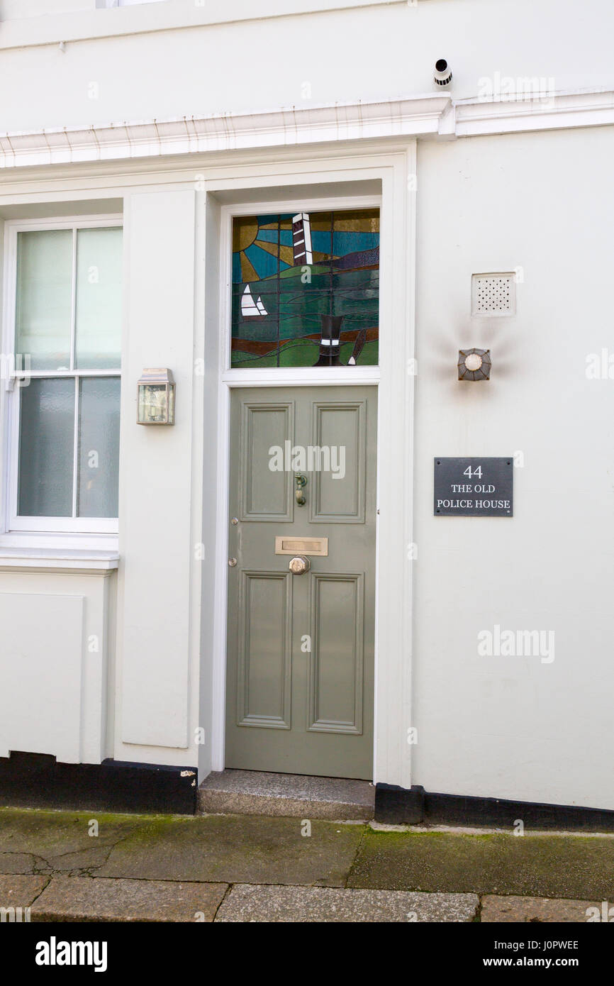 Un moderno pezzo di vetro macchiato sopra la vecchia porta della vecchia casa di polizia nel porto storico di Fowey, Cornwall, Inghilterra Foto Stock