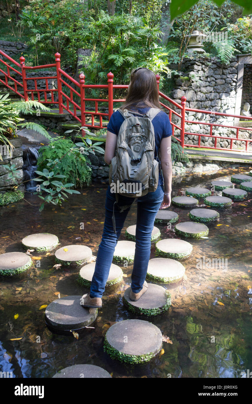 Un turista rende il loro modo attraverso le pietre miliari nel Monte Palace Tropical Garden, Funchal Foto Stock