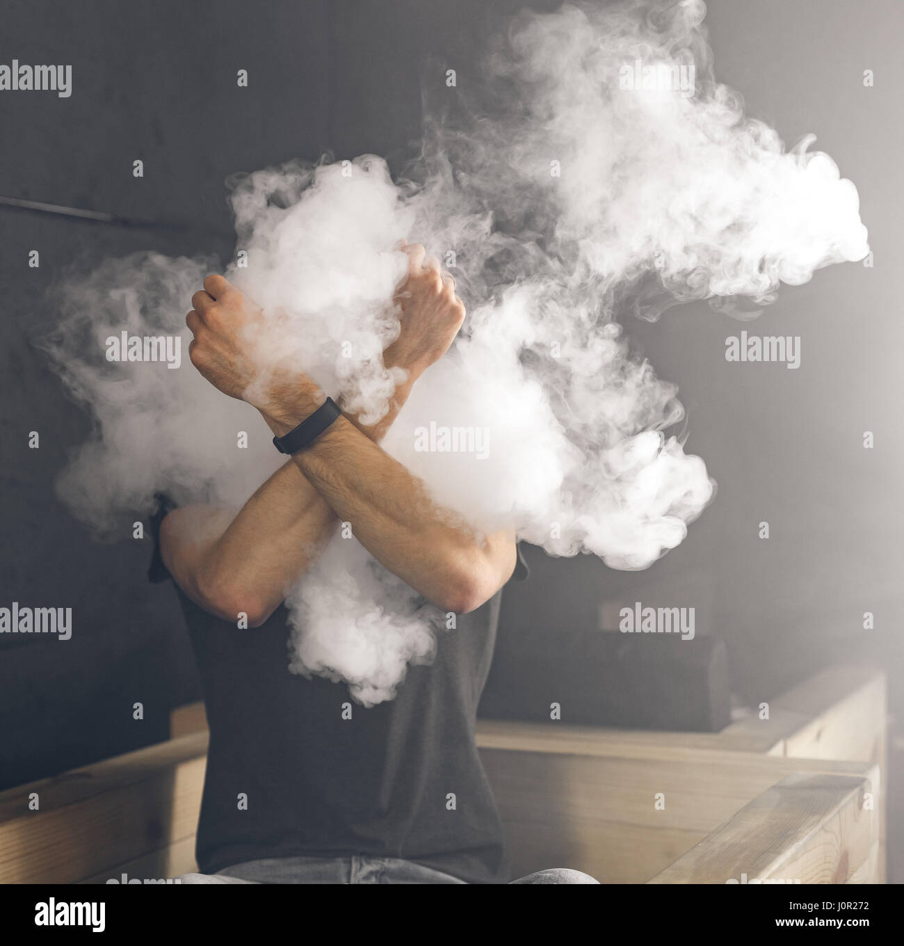Il fumo fuoriesce del fumo. L uomo è vaping in camera oscura Foto Stock