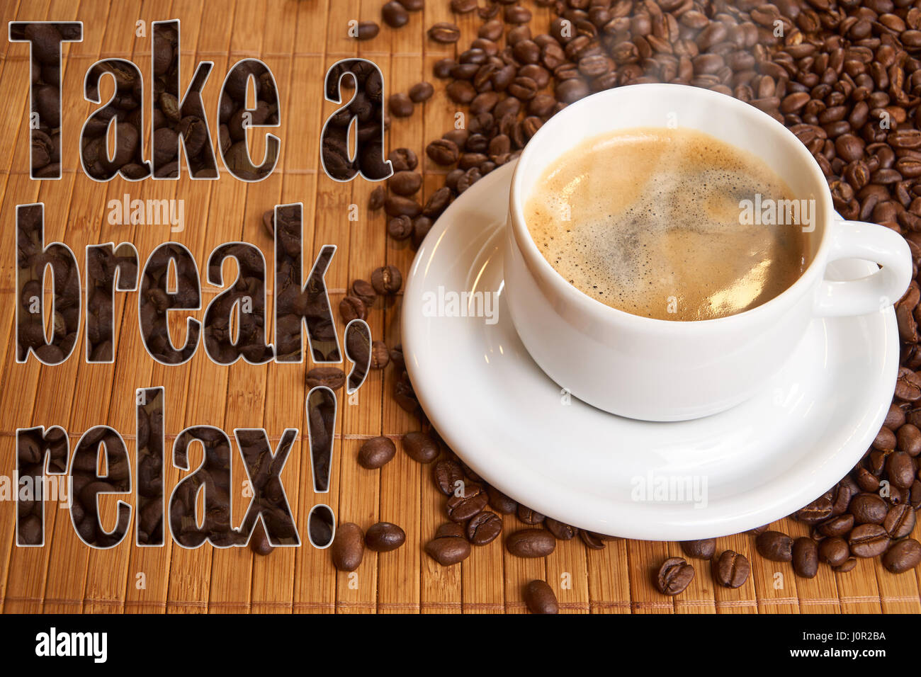 Una tazza di caffè nero sul bambù circondato da chicchi di caffè - con il testo: prendere una pausa, di relax. Foto Stock