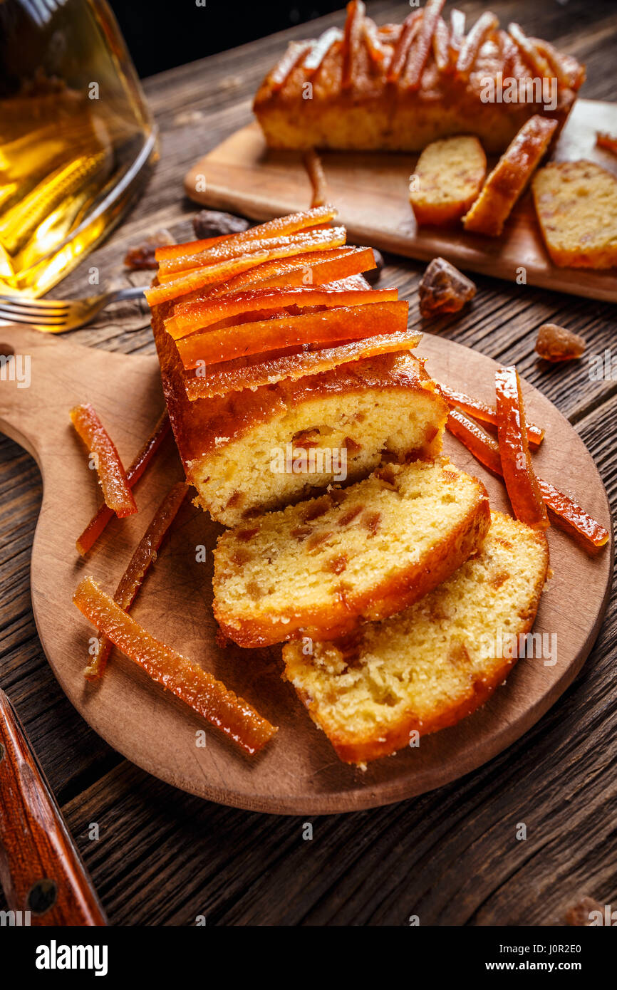 Torta con canditi di scorza di arancia sul tagliere di legno Foto Stock