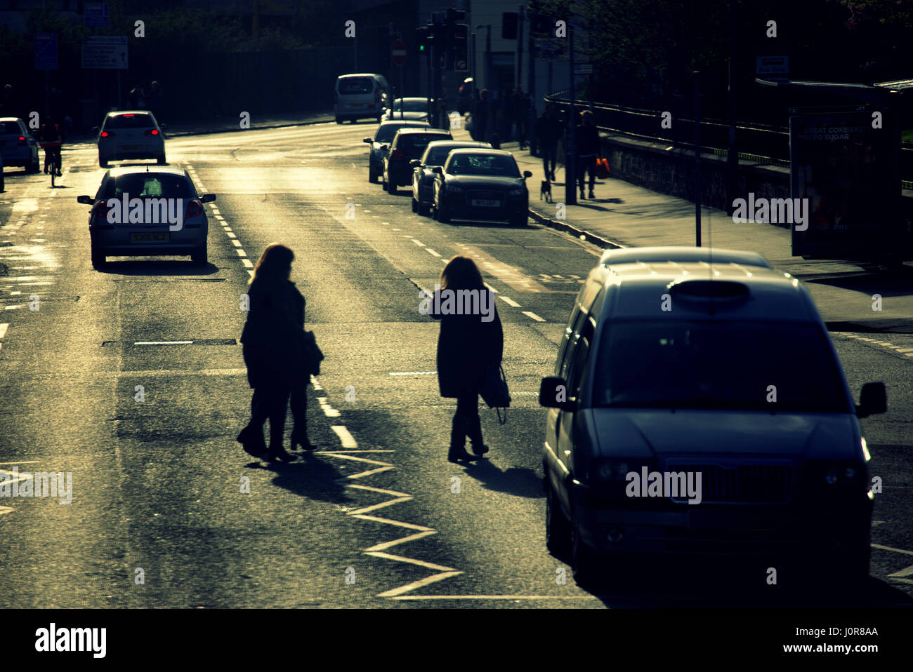 Jaywalking donne jaywalkers su Duke Street Dennistoun Glasgow silhouette centrale di strada Foto Stock