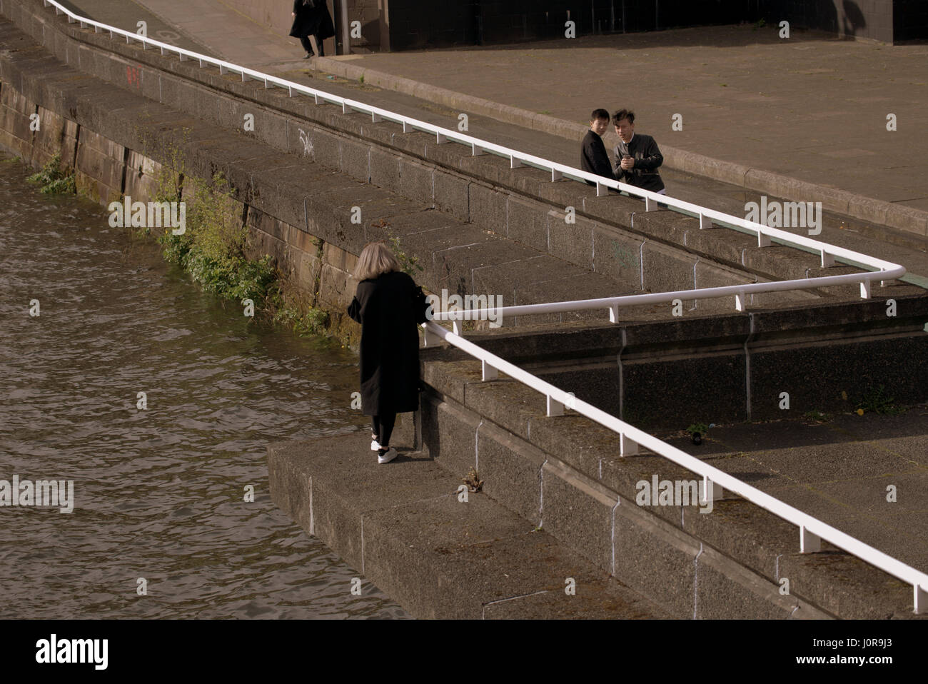 Giovani cinesi turisti adolescenti fotografie racconto tipo selfie foto sul fiume Clyde Glasgow la riproduzione di suicidio Foto Stock