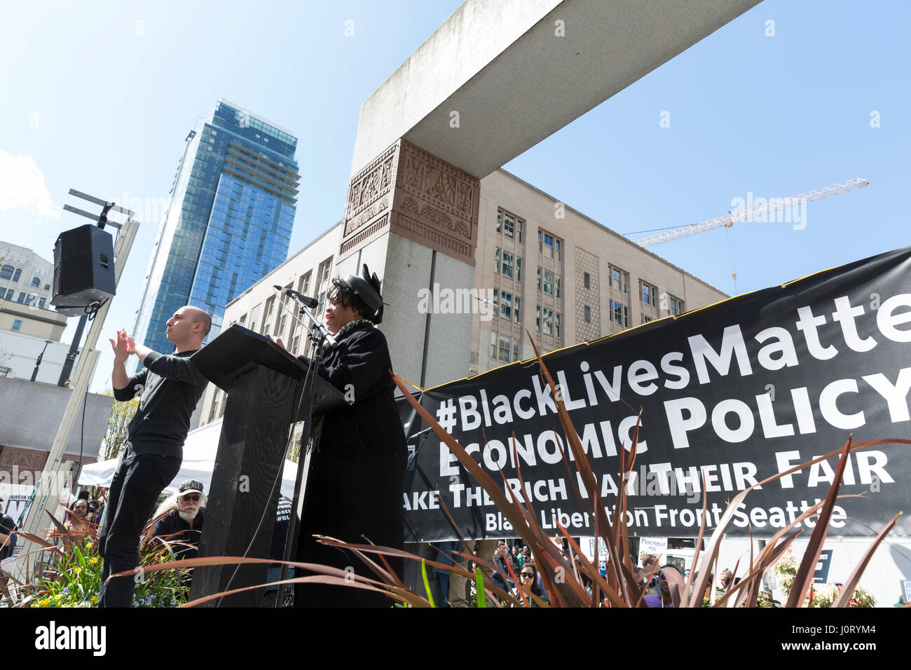 Seattle, Washington, Stati Uniti d'America. Il 15 aprile, 2017. Attivista della comunità parla di sostenitori al rally in West Lake Park. Migliaia di manifestanti hanno partecipato nero vive questione marzo su Seattle 2.0 protestando un sistema fiscale che non riconosce il valore di persone di colore e persone emarginate. Gli attivisti anche la domanda che il Presidente Trump rilasciare la sua dichiarazione fiscale e a rivelare i suoi rapporti commerciali, legami finanziari e di eventuali potenziali conflitti di interessi. Credito: Paolo Gordon/Alamy Live News Foto Stock