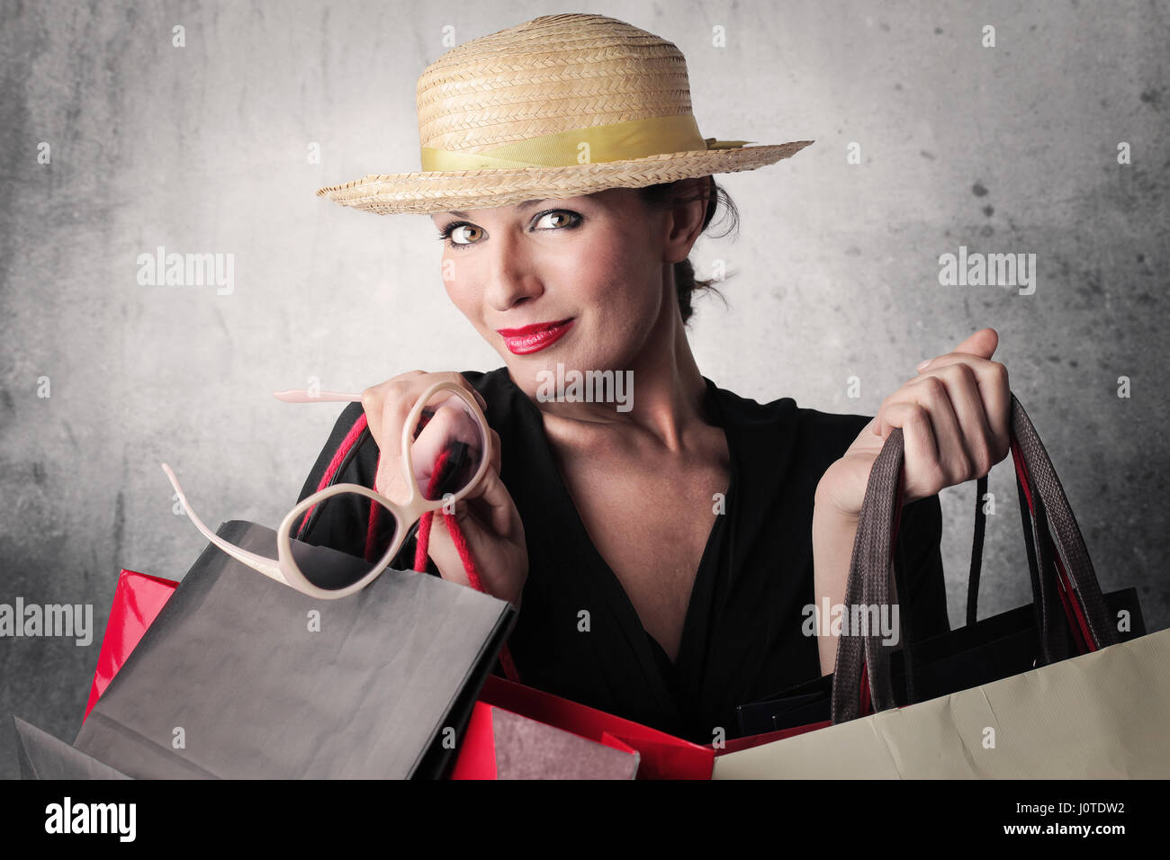 Donna con cappello di borse per lo shopping Foto Stock