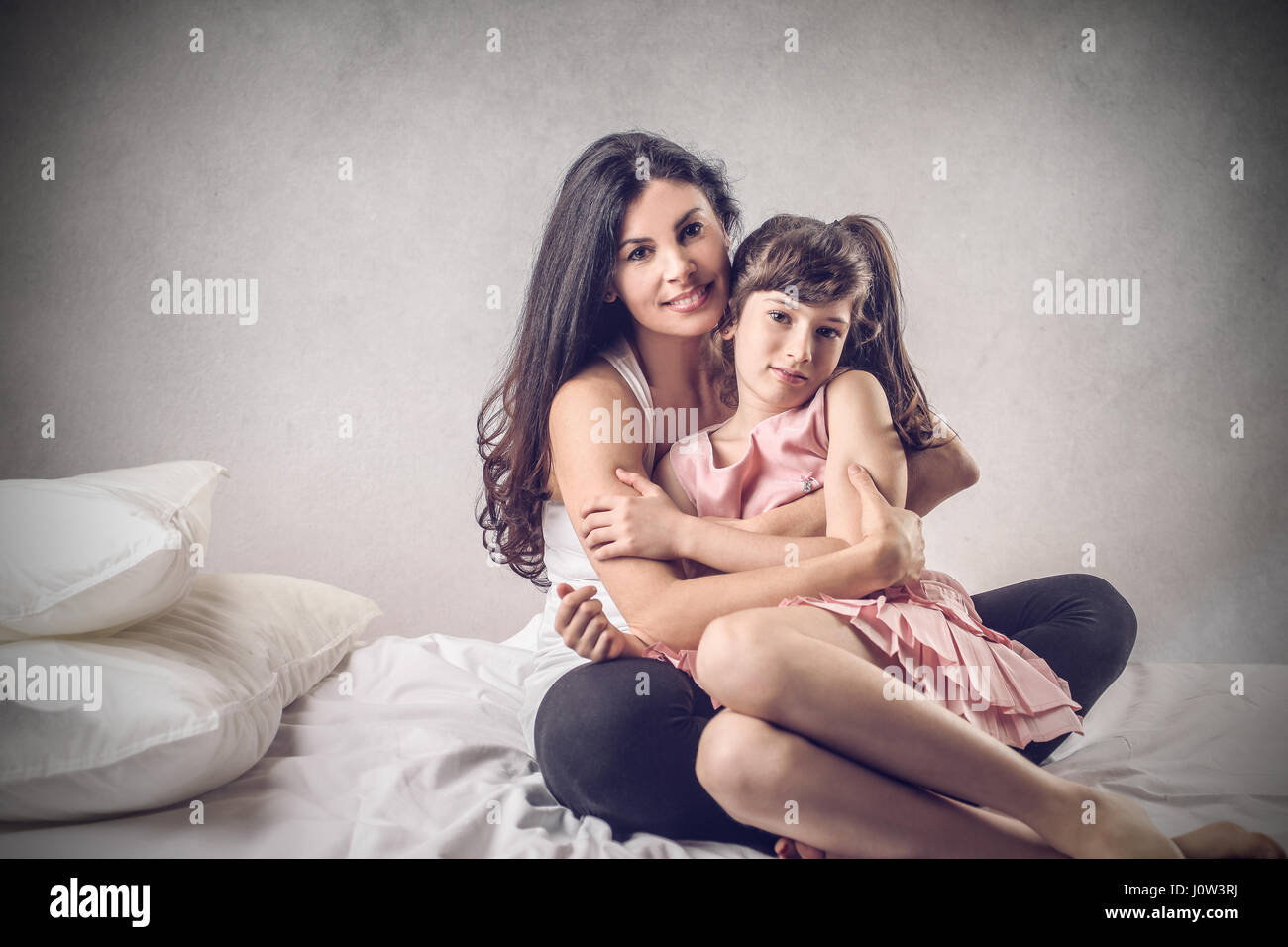 La madre abbraccia la figlia Foto Stock