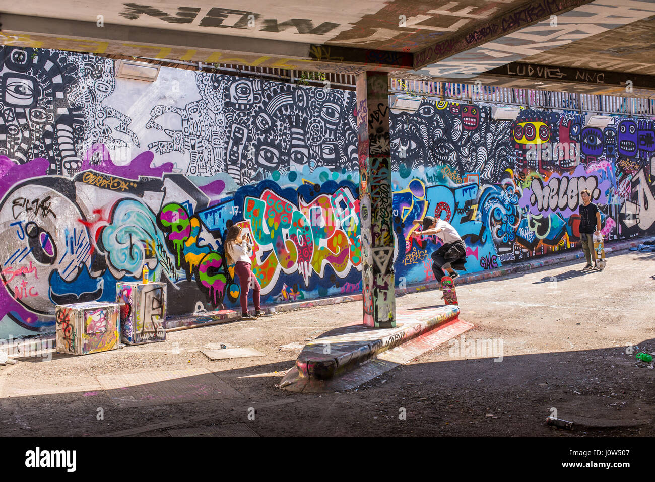 Adolescente skater cavalcare uno skateboard di eseguire un trick in Leake Street tunnel, Londra, Regno Unito. Leake street noto anche come 'Graffiti 'tunnel' o 'Banche Foto Stock