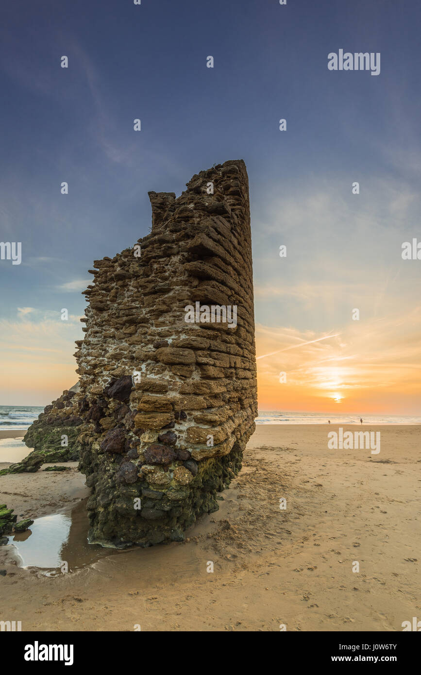 Torre del Loro Parque torre romana rovine sulla spiaggia di Mazagon,Spagna presso il bellissimo tramonto. Foto Stock