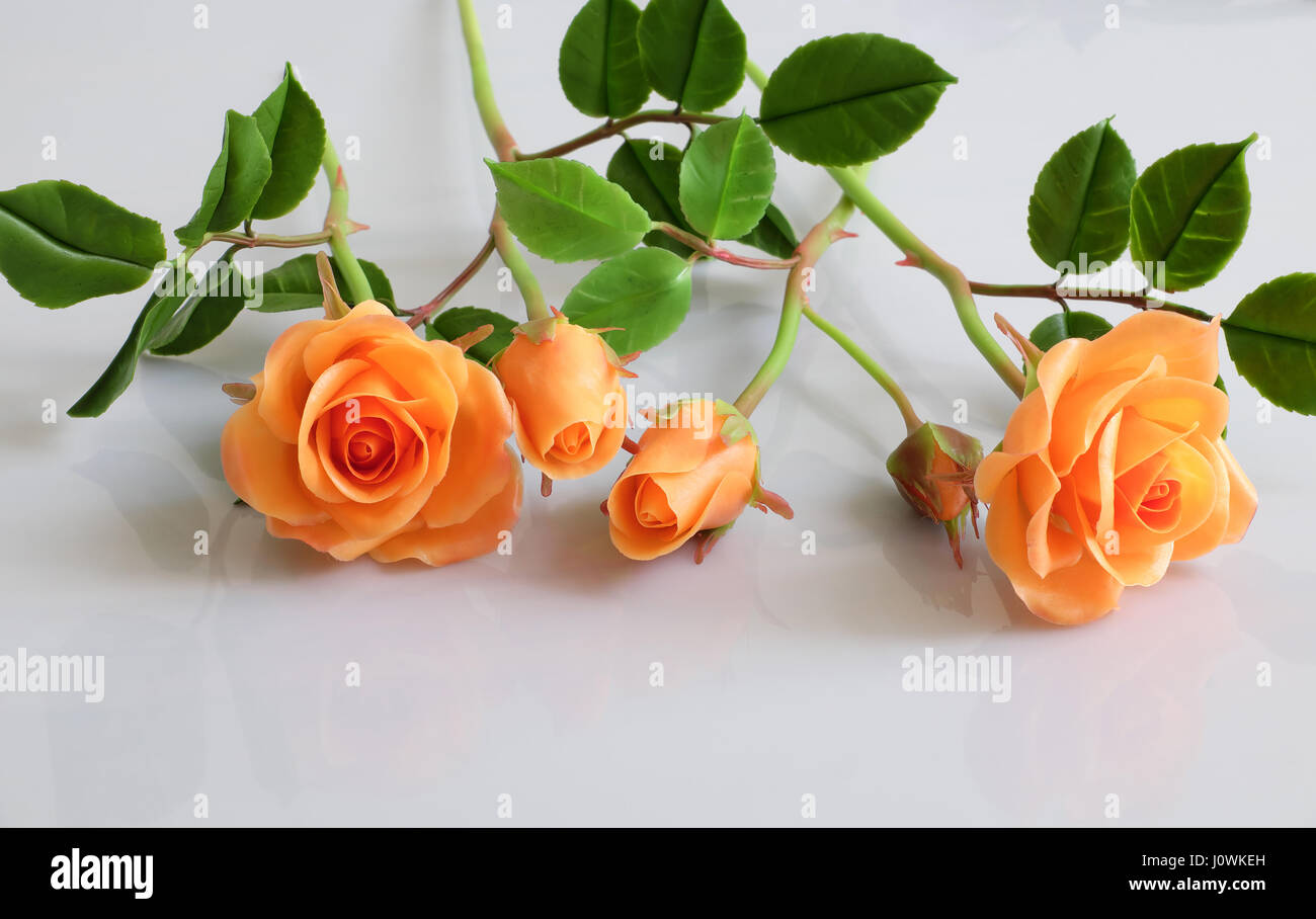 Meravigliosa arte di argilla con orange Rose fiore relect su sfondo bianco, bellissimi fiori artificiali di artigianato Foto Stock