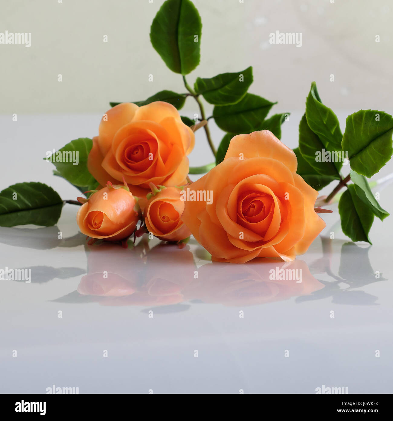 Meravigliosa arte di argilla con orange Rose fiore relect su sfondo bianco, bellissimi fiori artificiali di artigianato Foto Stock