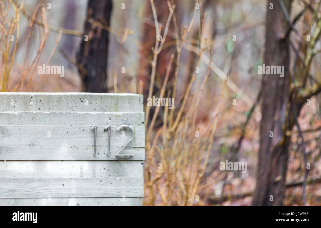 Il numero 112 su un blocco in calcestruzzo nei boschi, in alloggiamenti di Hampton NY Foto Stock