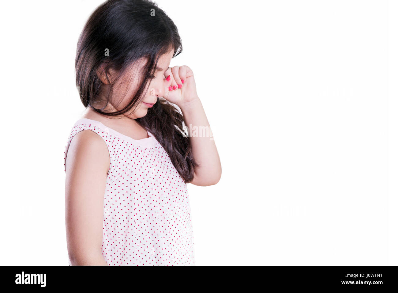 Triste pianto infelice piccola bella ragazza con capelli e occhi scuri. studio shot, isolato su sfondo bianco. Foto Stock