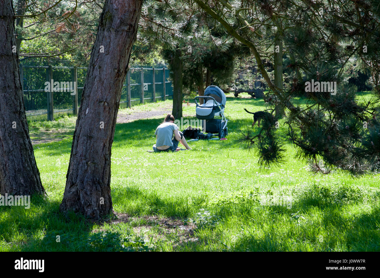 Madre con una carrozzina e il bambino a riposare nel giardino del castello Foto Stock