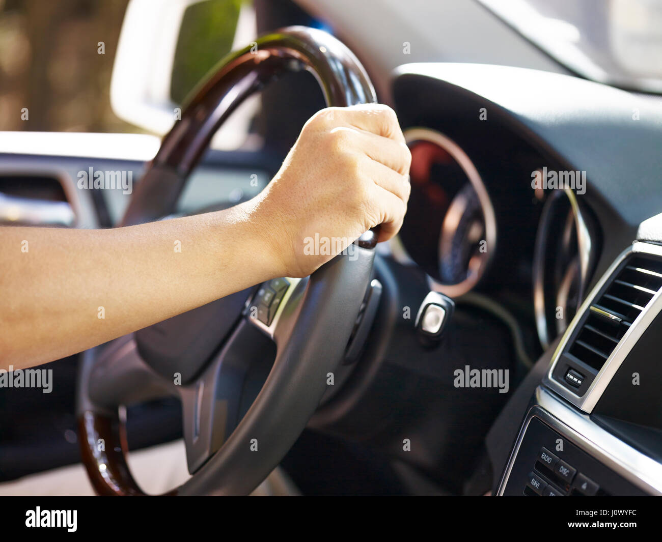 La mano di una persona che tiene il volante. Foto Stock