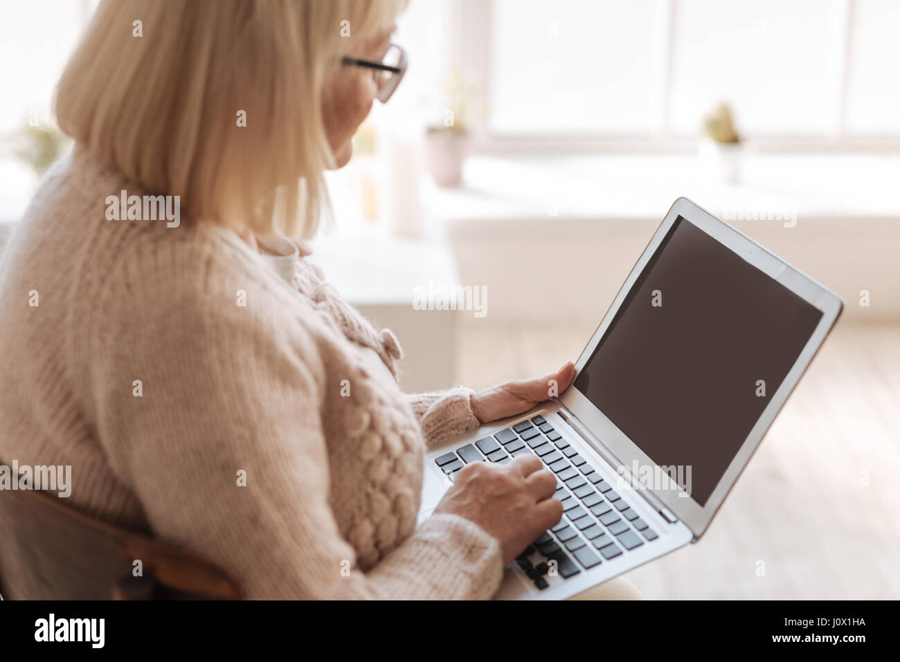 Nizza dai capelli grigi donna digitando Foto Stock