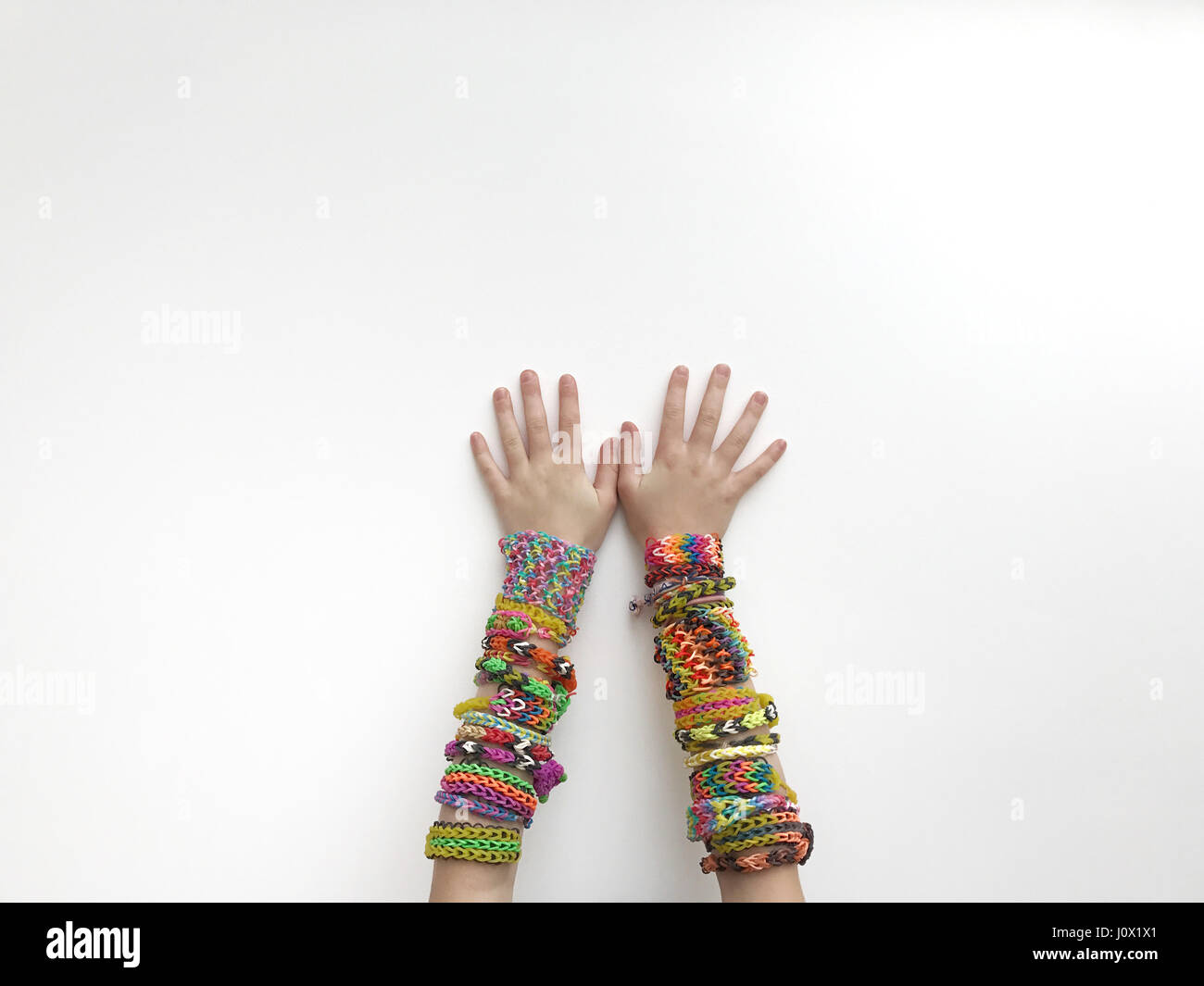 Ragazza che indossa in casa colorati braccialetti del telaio Foto Stock