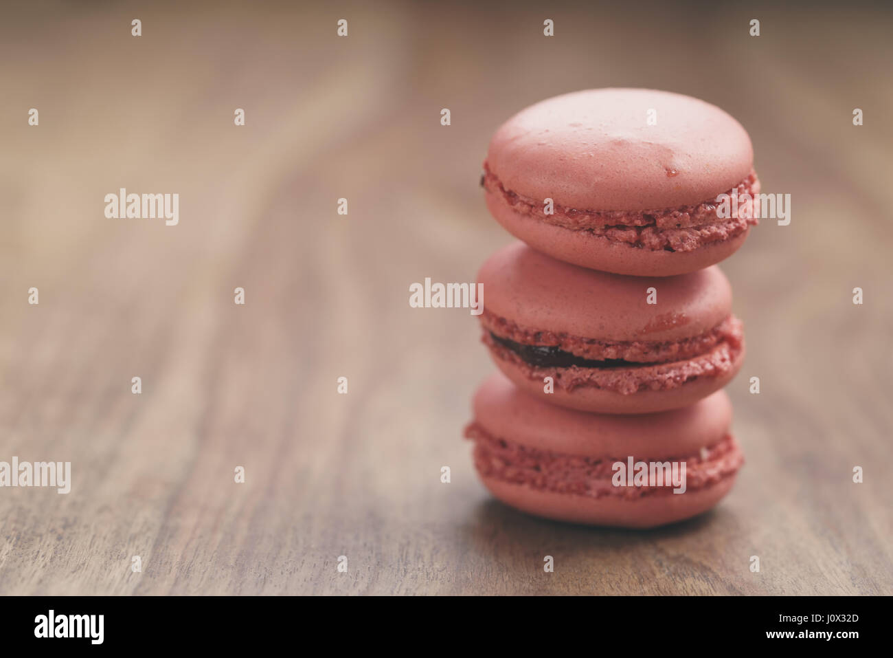 Closeup shot pila di color pastello macarons con sapore di fragola sulla tavola di legno Foto Stock