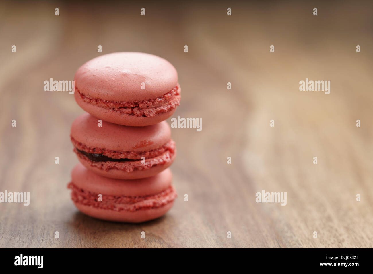 Closeup shot pila di color pastello macarons con sapore di fragola sulla tavola di legno Foto Stock
