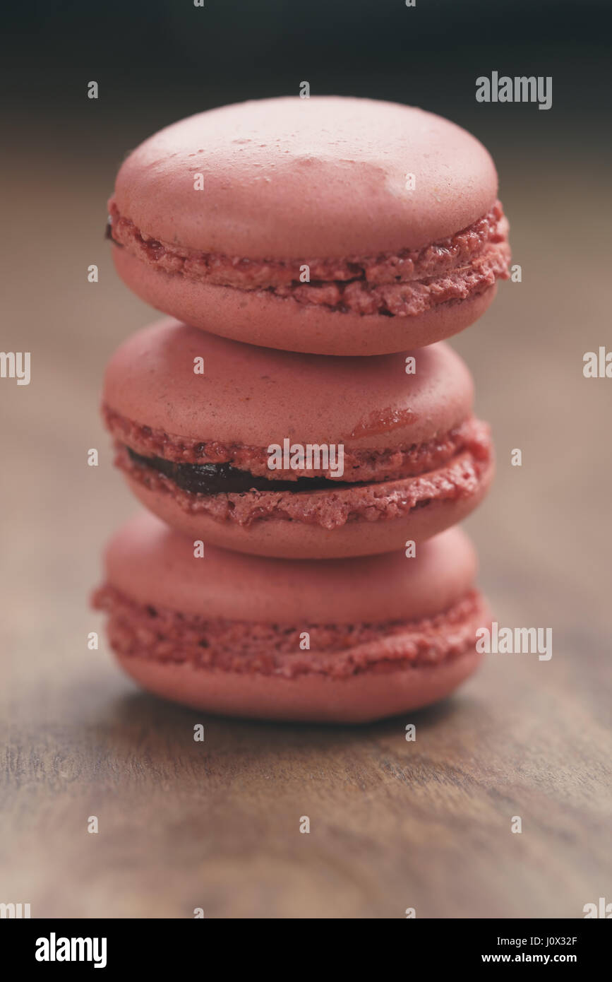 Closeup shot pila di color pastello macarons con sapore di fragola sulla tavola di legno Foto Stock