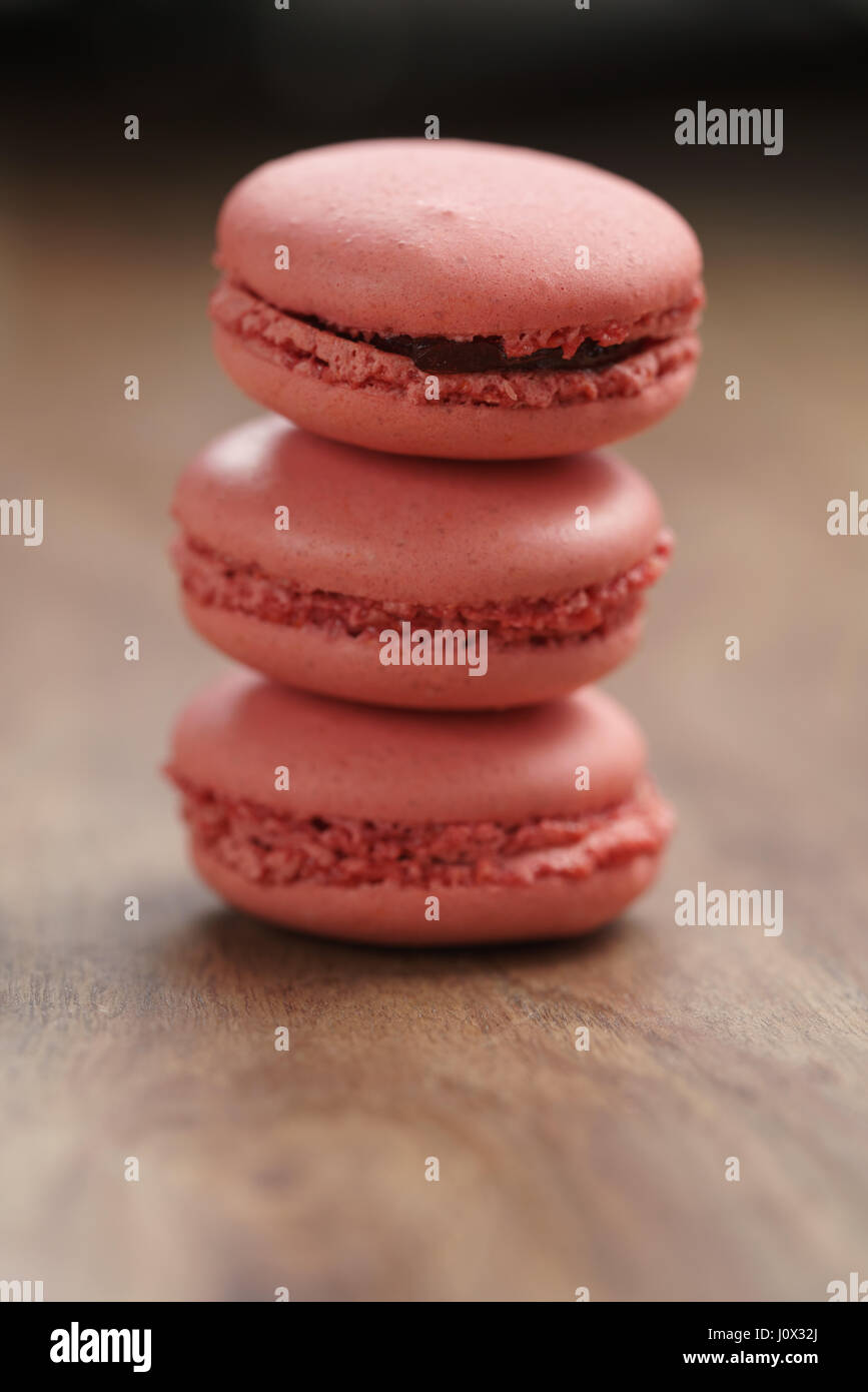 Closeup shot pila di color pastello macarons con sapore di fragola sulla tavola di legno Foto Stock