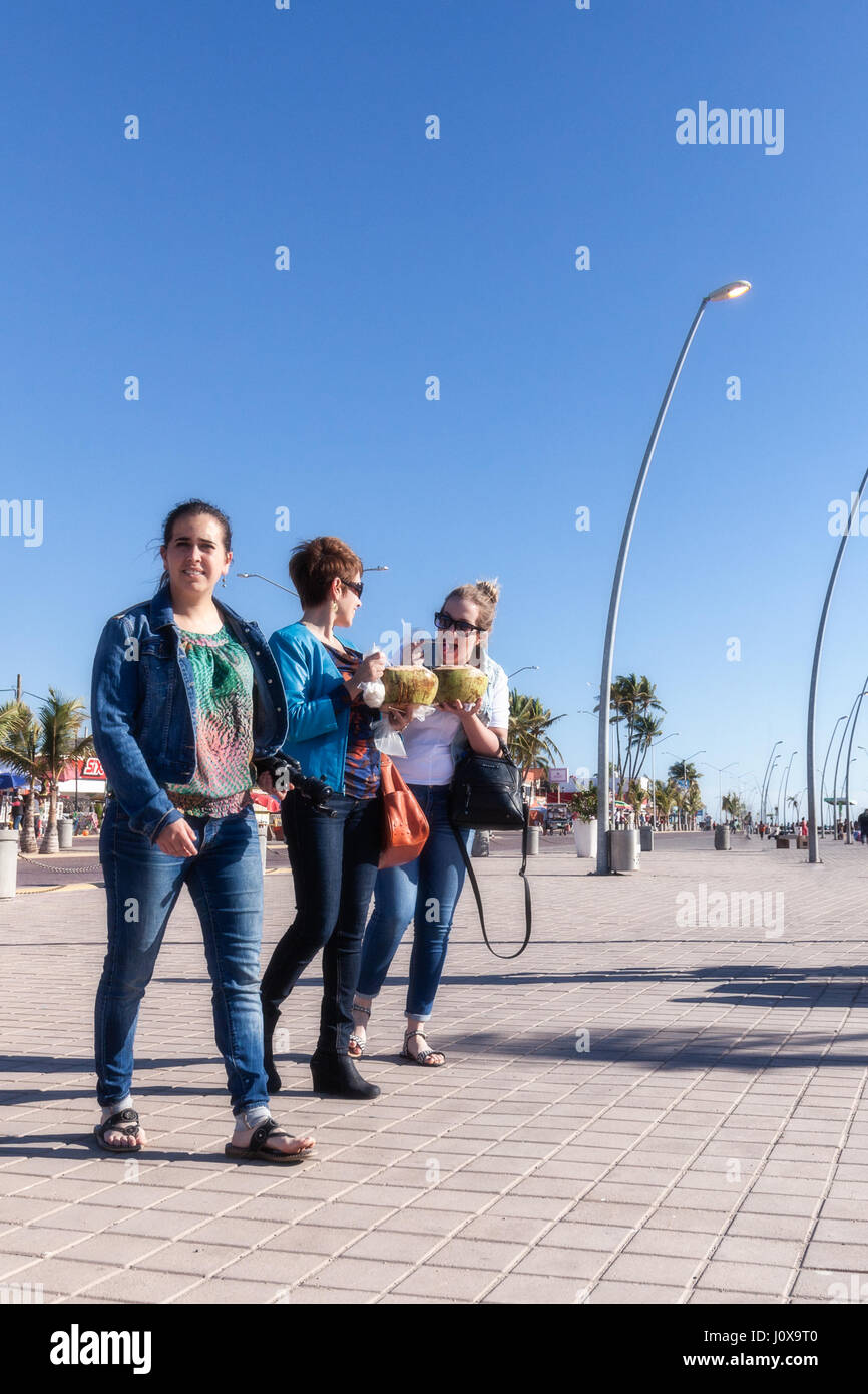 Una madre e le sue figlie a piedi lungo la passeggiata a mare di Altata, Sinaloa, Messico. Foto Stock