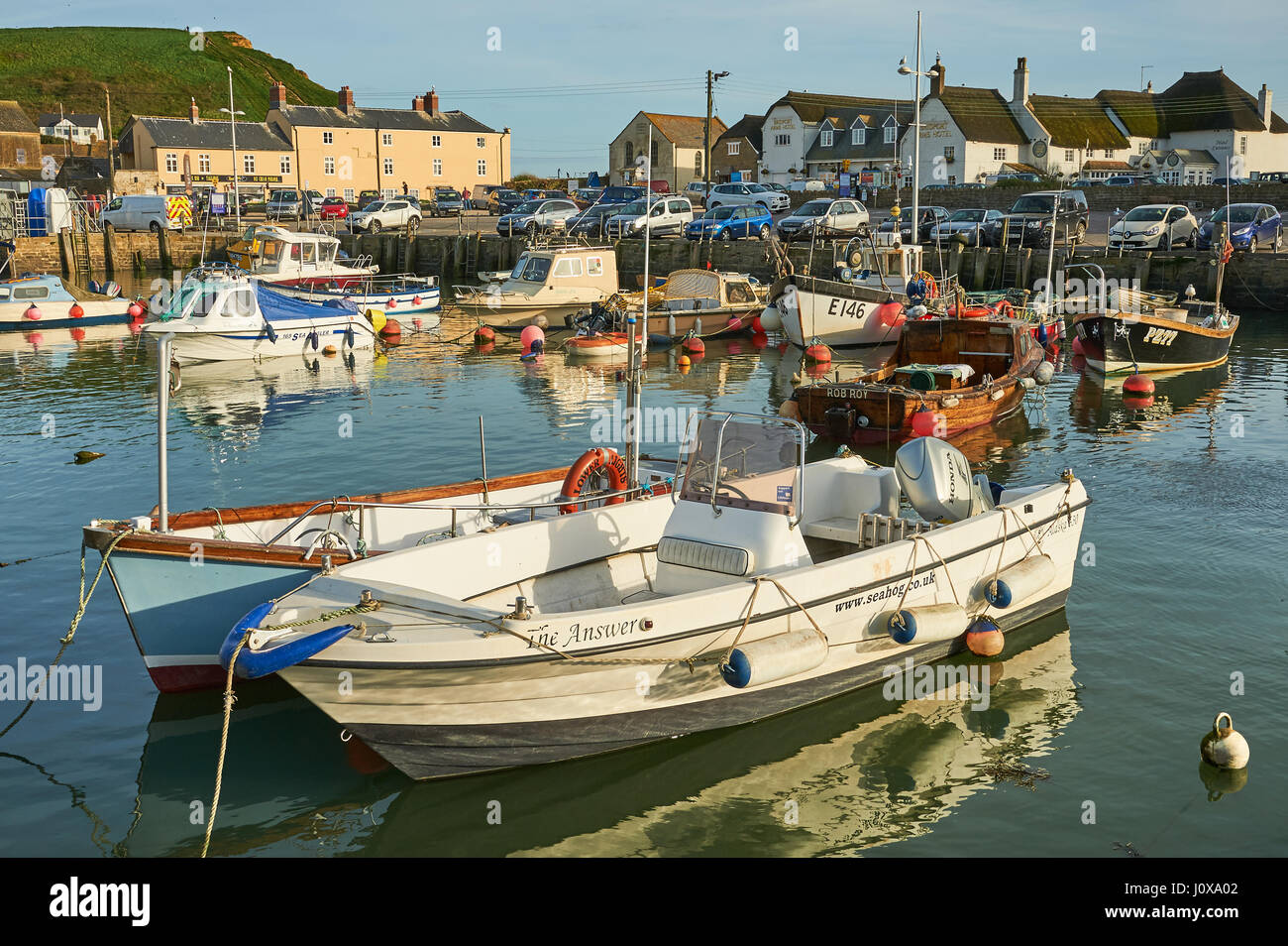 Alta Marea, barche da pesca e le navi per la pesca a strascico nella piccola località balneare di West Bay su Dorset la Jurassic Coast. Foto Stock