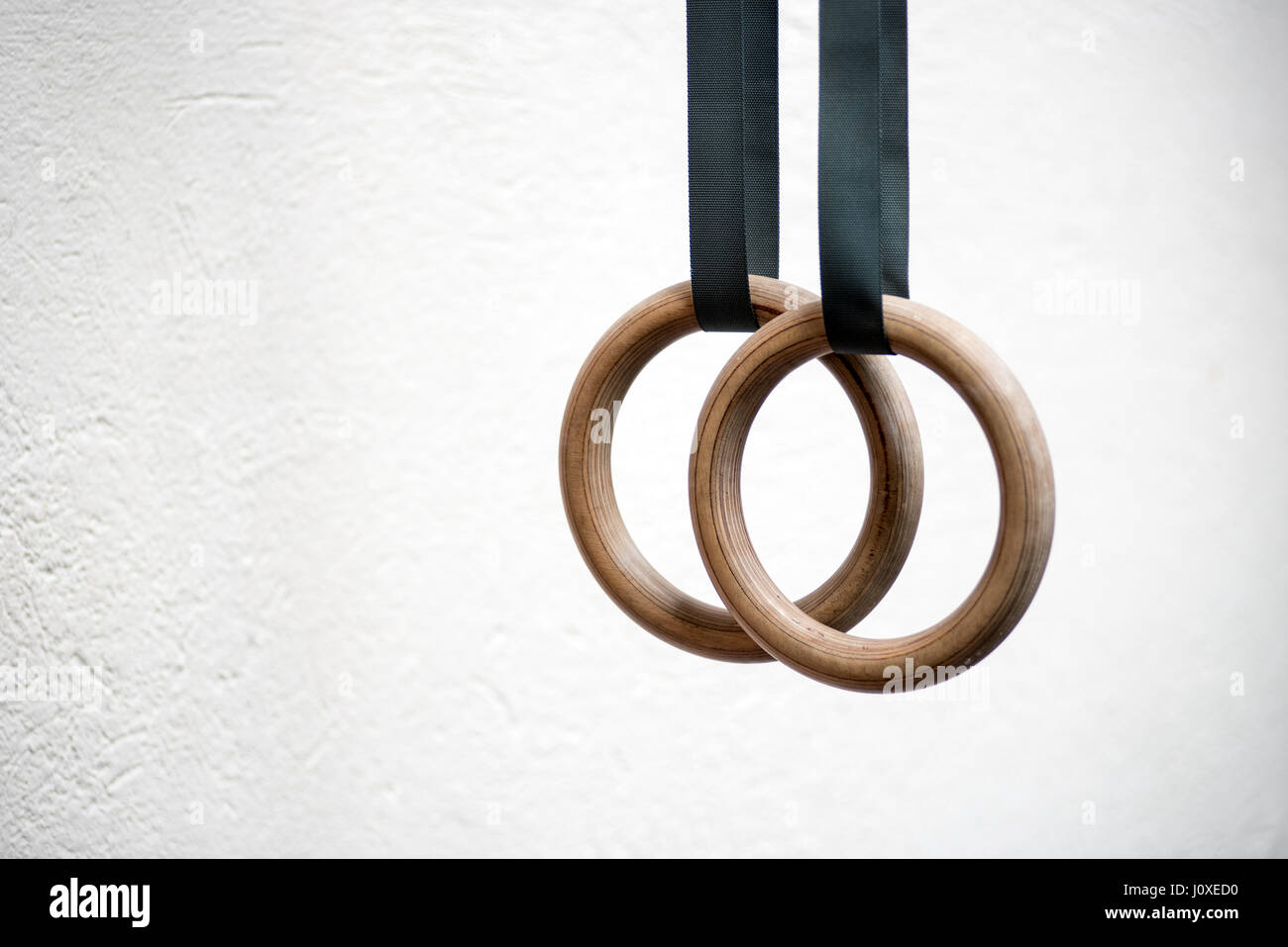 Dettaglio di una serie di anelli o anelli di costante, in una palestra su un muro bianco con copia spazio in uno stile di vita sano e concetto di fitness Foto Stock