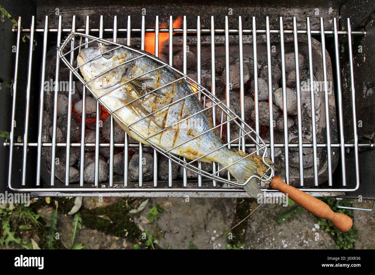 Orata in cesto di pesce sul barbecue a carbone Foto stock - Alamy