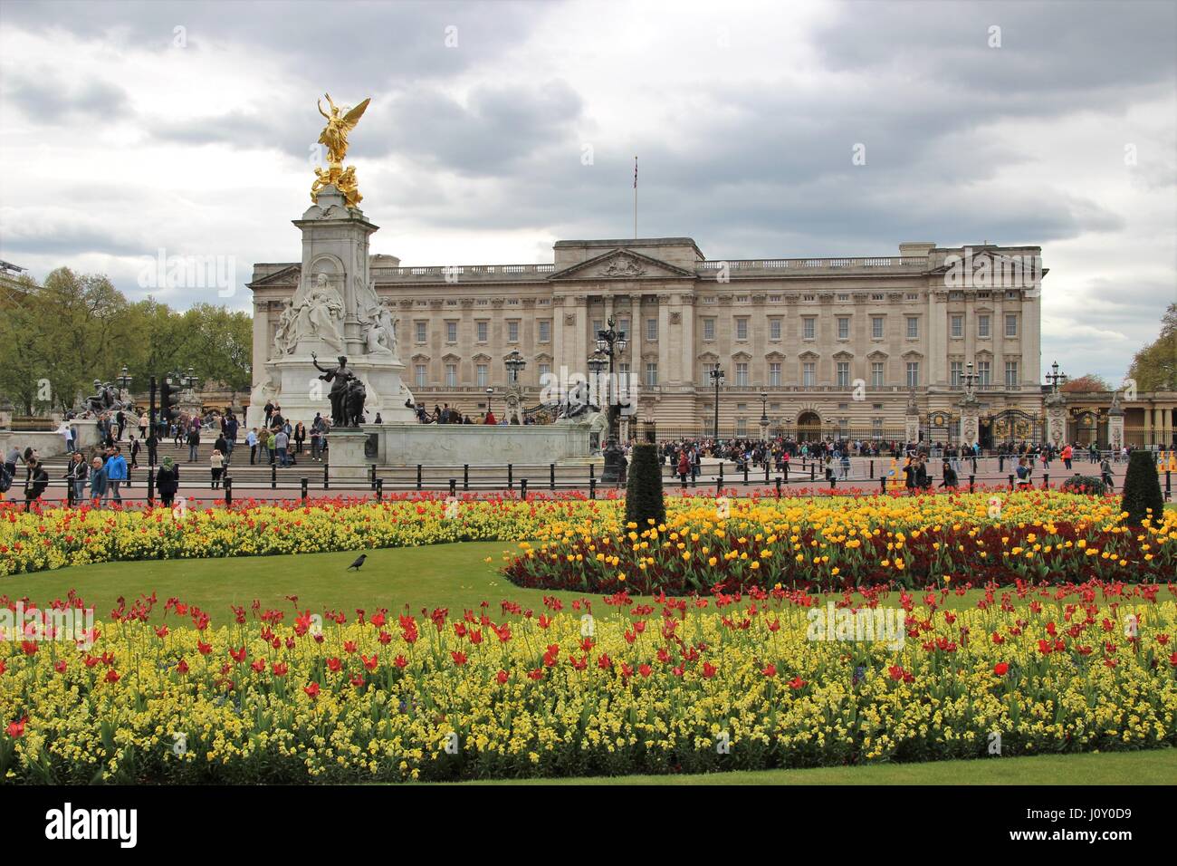 Buckingham Palace, residenza londinese della monarchia, con il memoriale della Victoria e letti di fiori Foto Stock