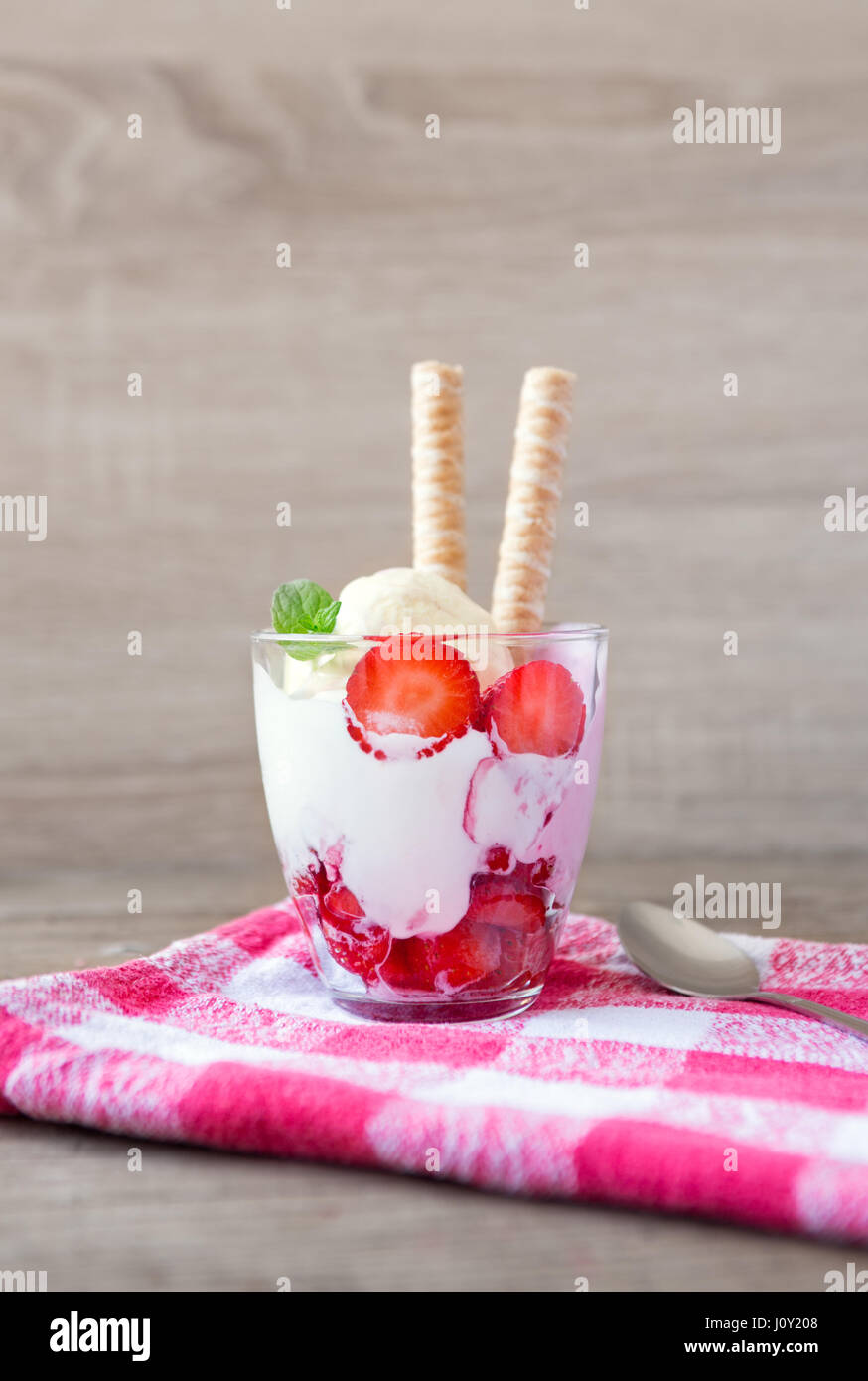 Le fragole dessert con biscotti e gelato servito in bicchieri Foto Stock