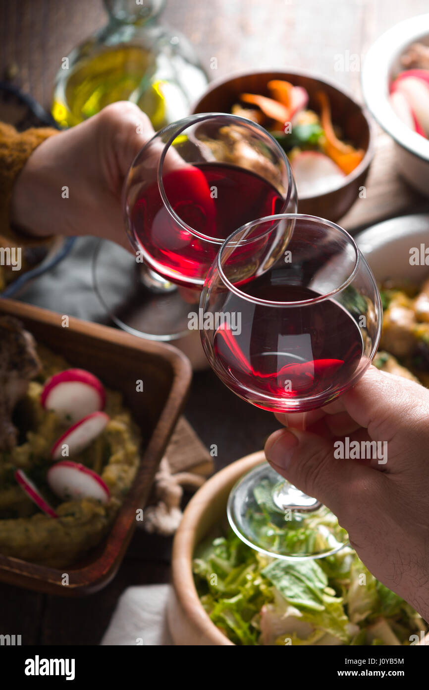 Occhiali con un drink in mano e insalate sulla verticale della tabella Foto Stock