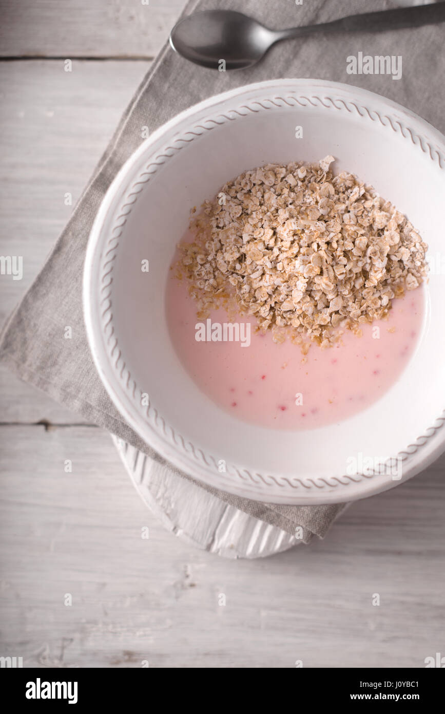 Yogurt alla frutta con scaglie di quercia sul bianco tavolo in legno vista superiore Foto Stock