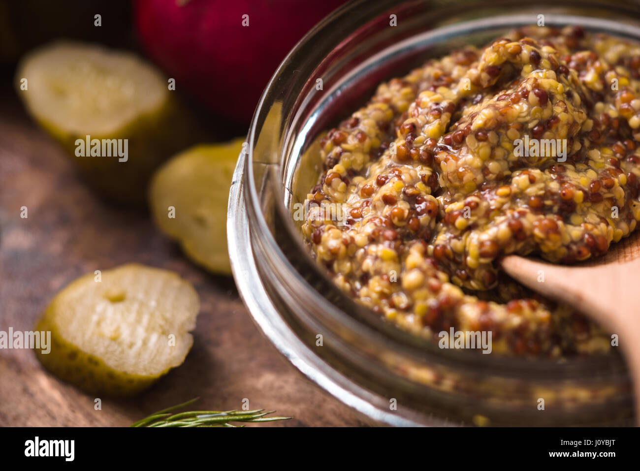 La senape con seme nella ciotola di vetro sul tavolo della cucina in orizzontale Foto Stock