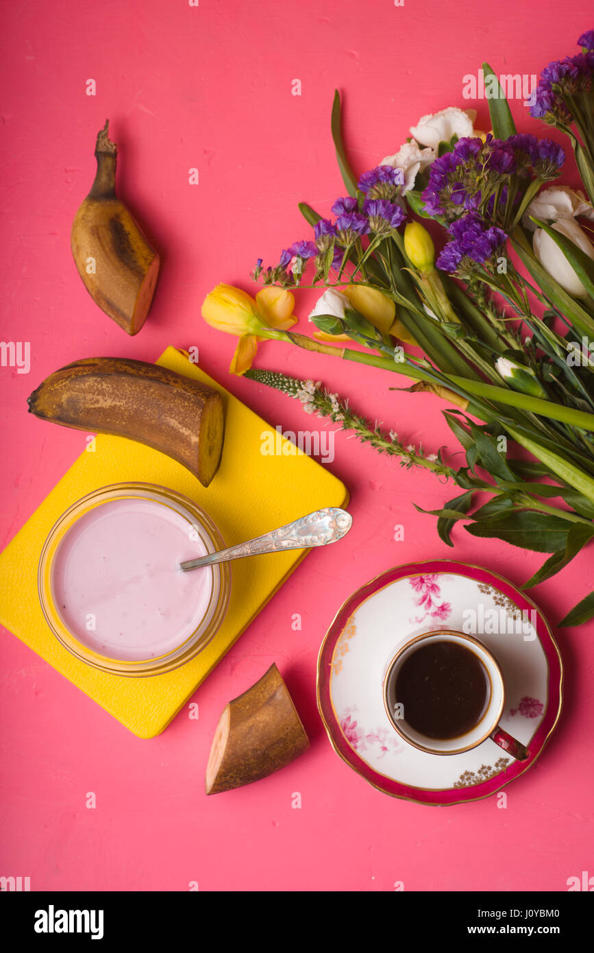 La prima colazione con yogurt, caffè e un mazzo di fiori Foto Stock