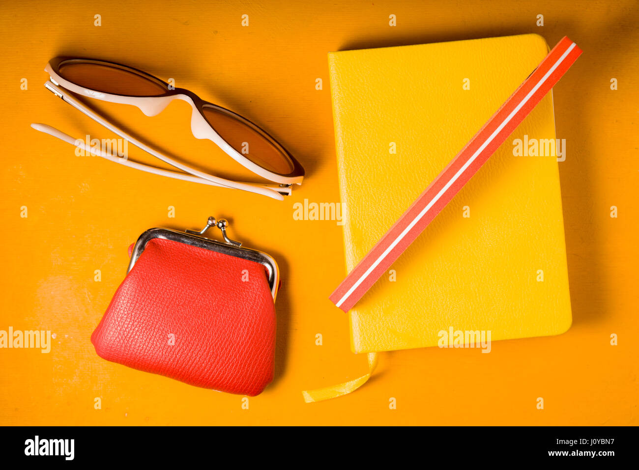 Blocco note giallo, bicchieri e portafoglio su un giallo pop art background Foto Stock