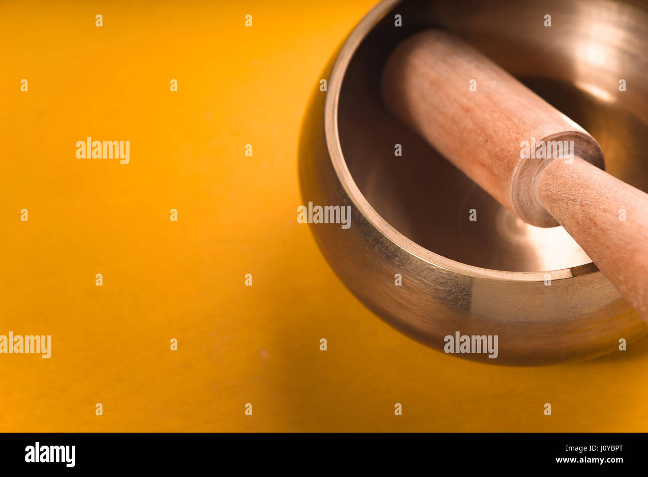 Recipiente di metallo con un bastone di legno su una tabella di colore giallo diagonal Foto Stock