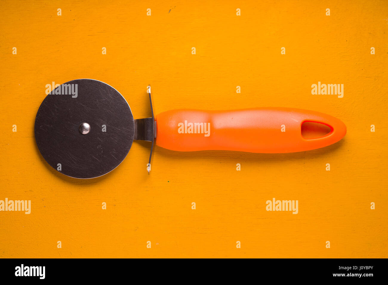 Pizza coltello sulla tavola gialla vista superiore Foto Stock