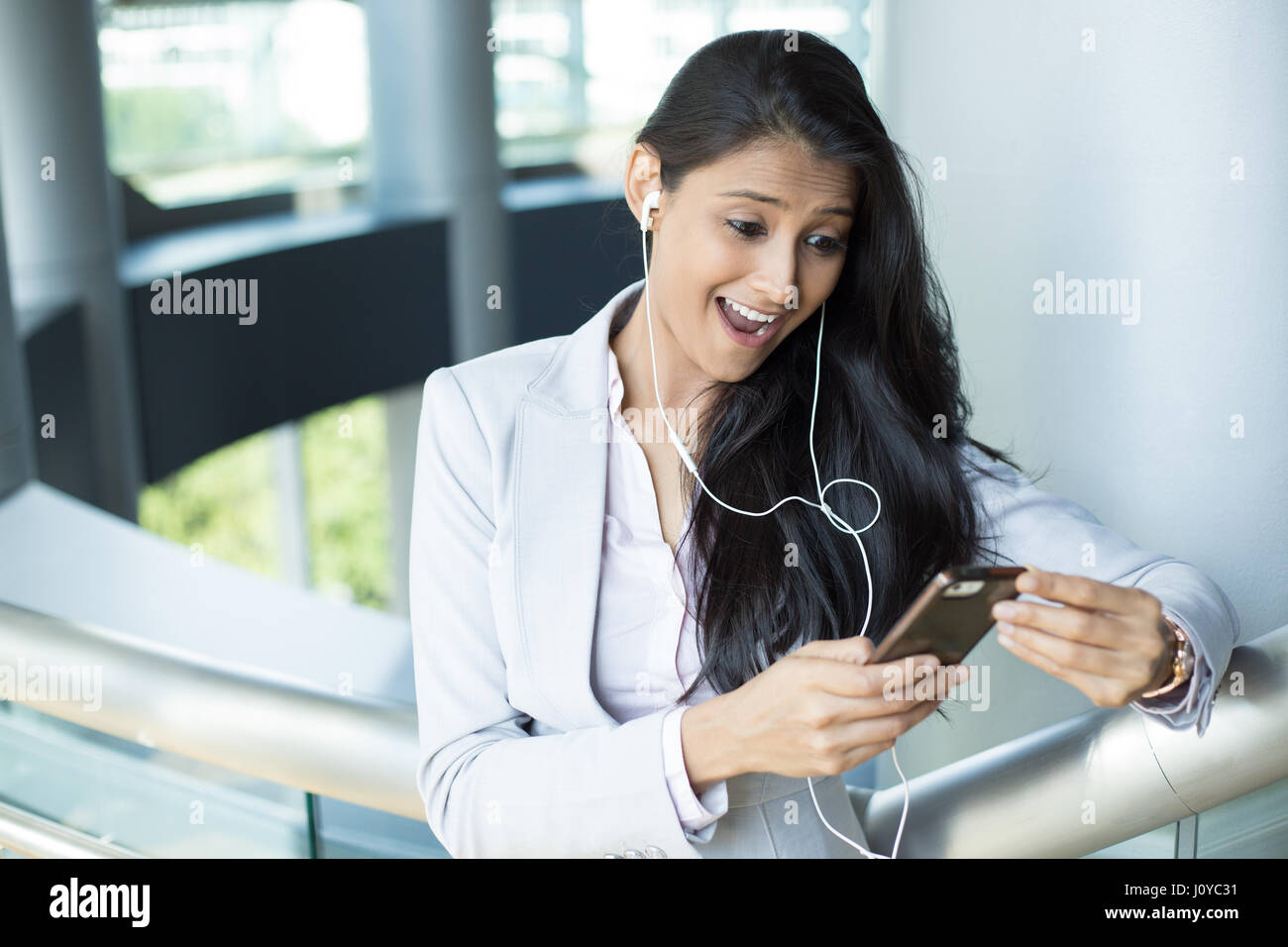 Closeup ritratto della bella giovane donna guardando scioccato, la bocca aperta e gli occhi, il telefono cellulare la visione di gioco sportivo match o la lettura di un sms, e-mail, visualizzazione Foto Stock