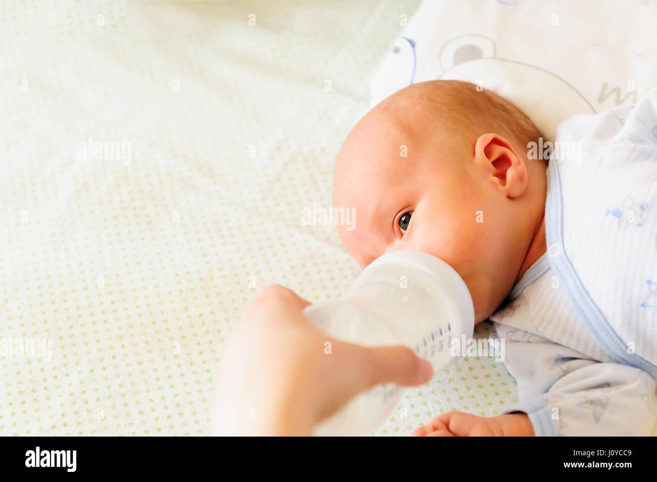Madre che nutre il suo bambino con una bottiglia di latte Foto Stock