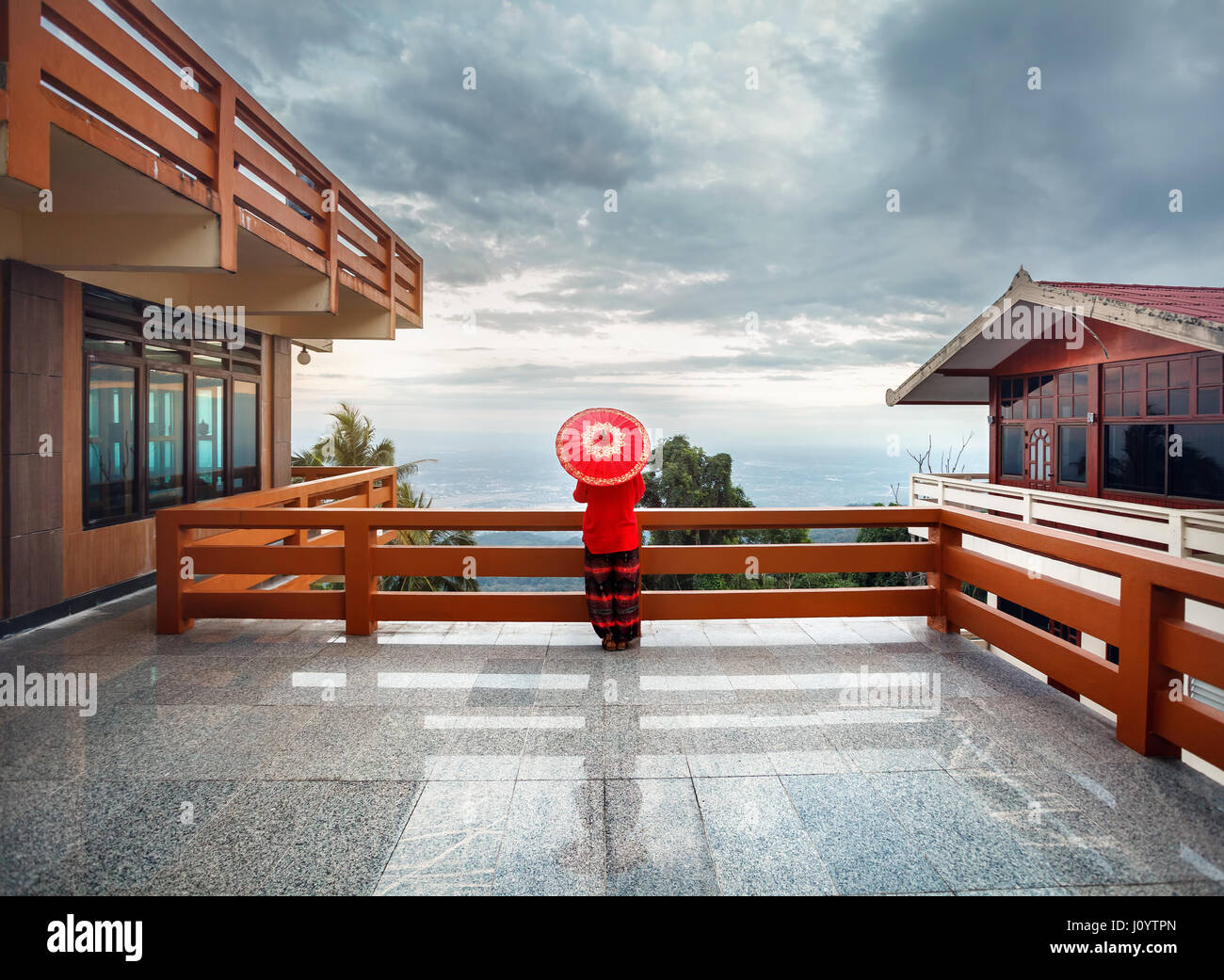 Donna con red Thai ombrellone al punto di vista guardando a Chiang Mai city panorama al tramonto in Thailandia Foto Stock