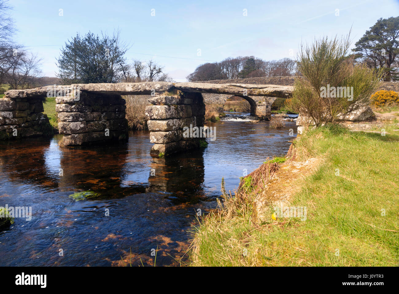 Antica battaglio ponte sull'est fiume Dart a Postbridge, Dartmoor, UK. Il ponte stradale è dietro. Foto Stock