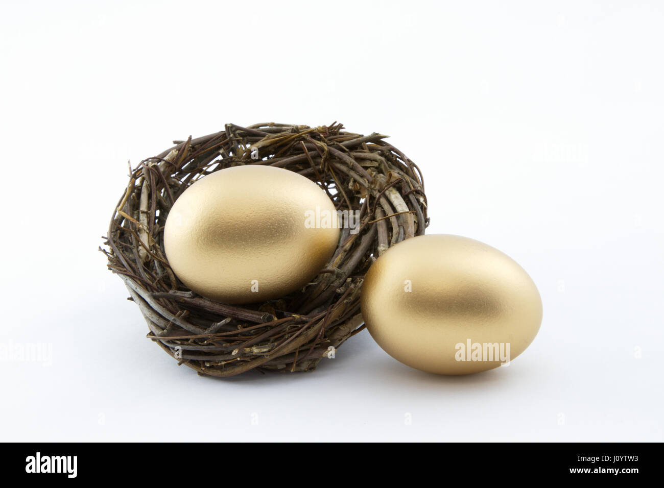 Business di successo di fortune in doppia simboli fortunati di due gold nest uova in orizzontale dell'immagine con sfondo bianco. Foto Stock