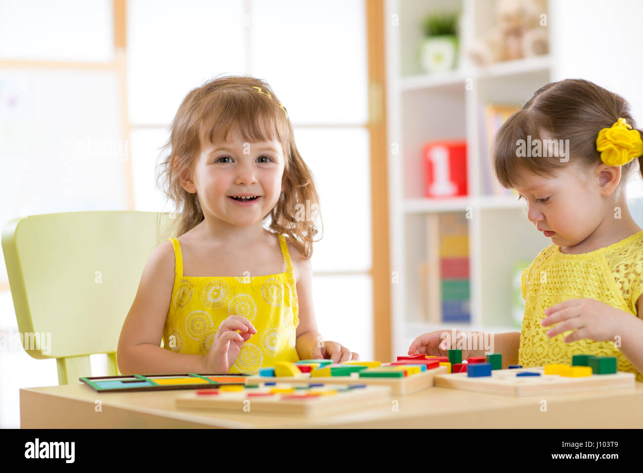 I bambini giocano con giocattoli educativi, disponendo e ordinamento di forme e colori. Apprendimento tramite esperienza concezione. Foto Stock