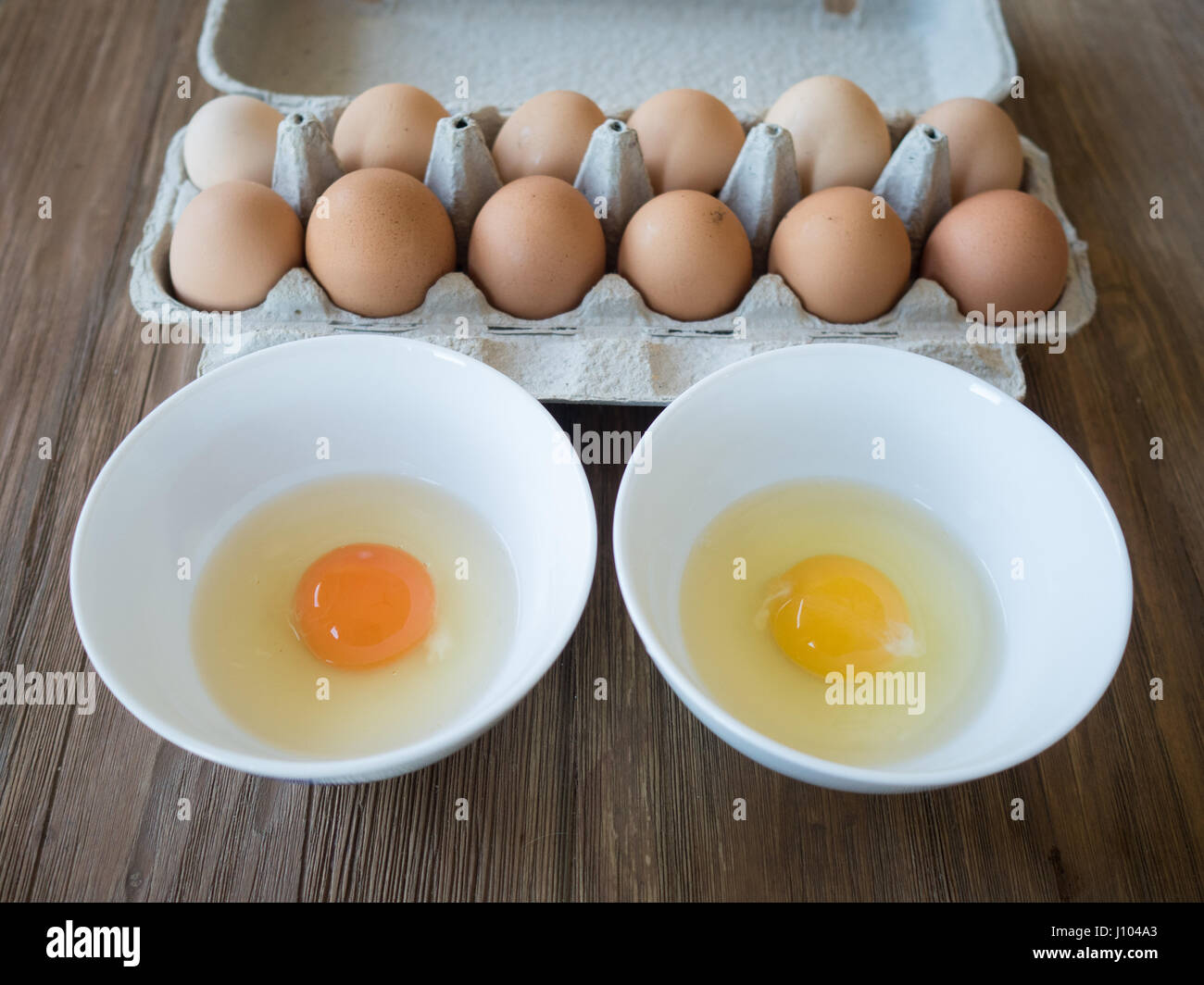 Uova di fattoria di pascolo biologico vs uova convenzionali: Un confronto fianco a fianco Foto Stock